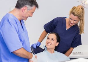 Dentist and nurse doing a dental exam, patient sitting in the dentist chair