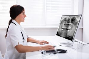 Dentist looking at a digital dental x-ray